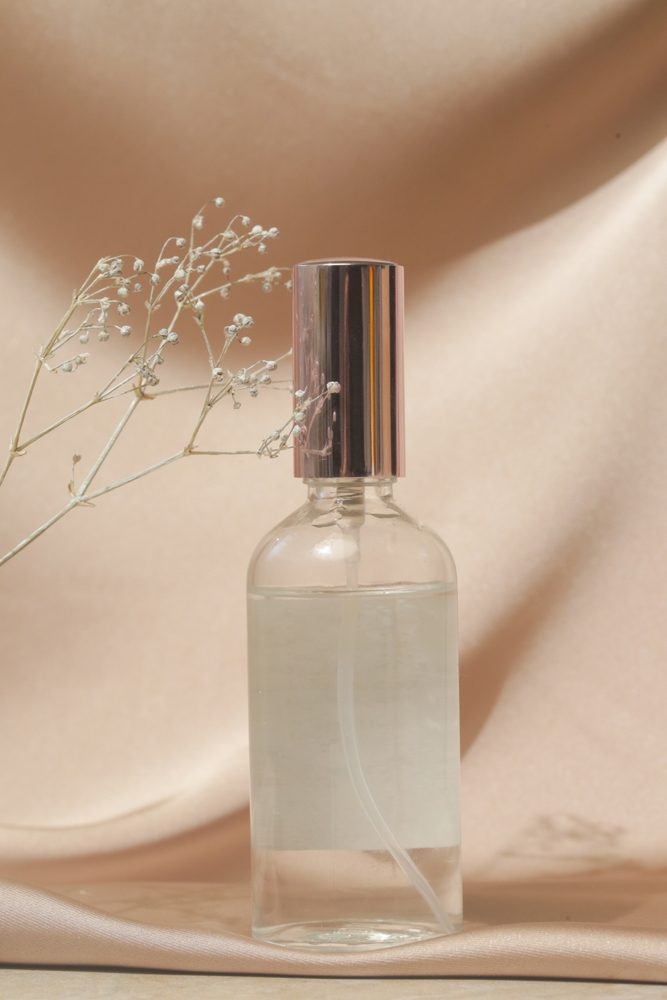 Glass,Translucent,Spray,Bottle,On,Soft,Folded,Silk,Background.,Luxury